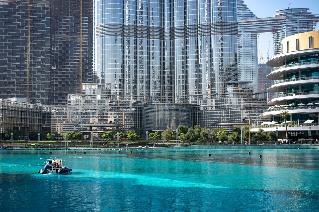 Burj Khalifa at golden hour with Dubai Fountain reflecting in nearby water
