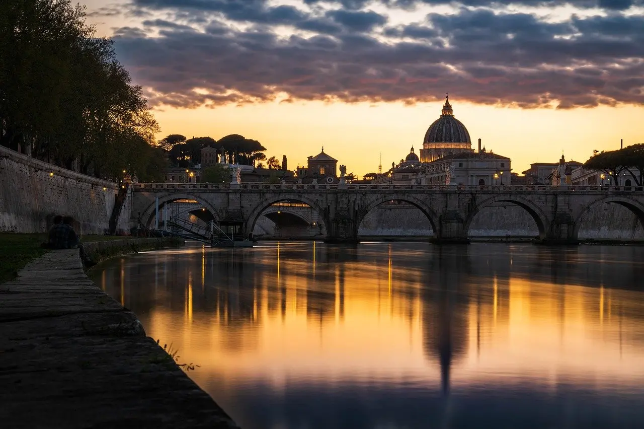 Sunrise view of St. Peter's Basilica dome with soft golden light over Rome rooftops