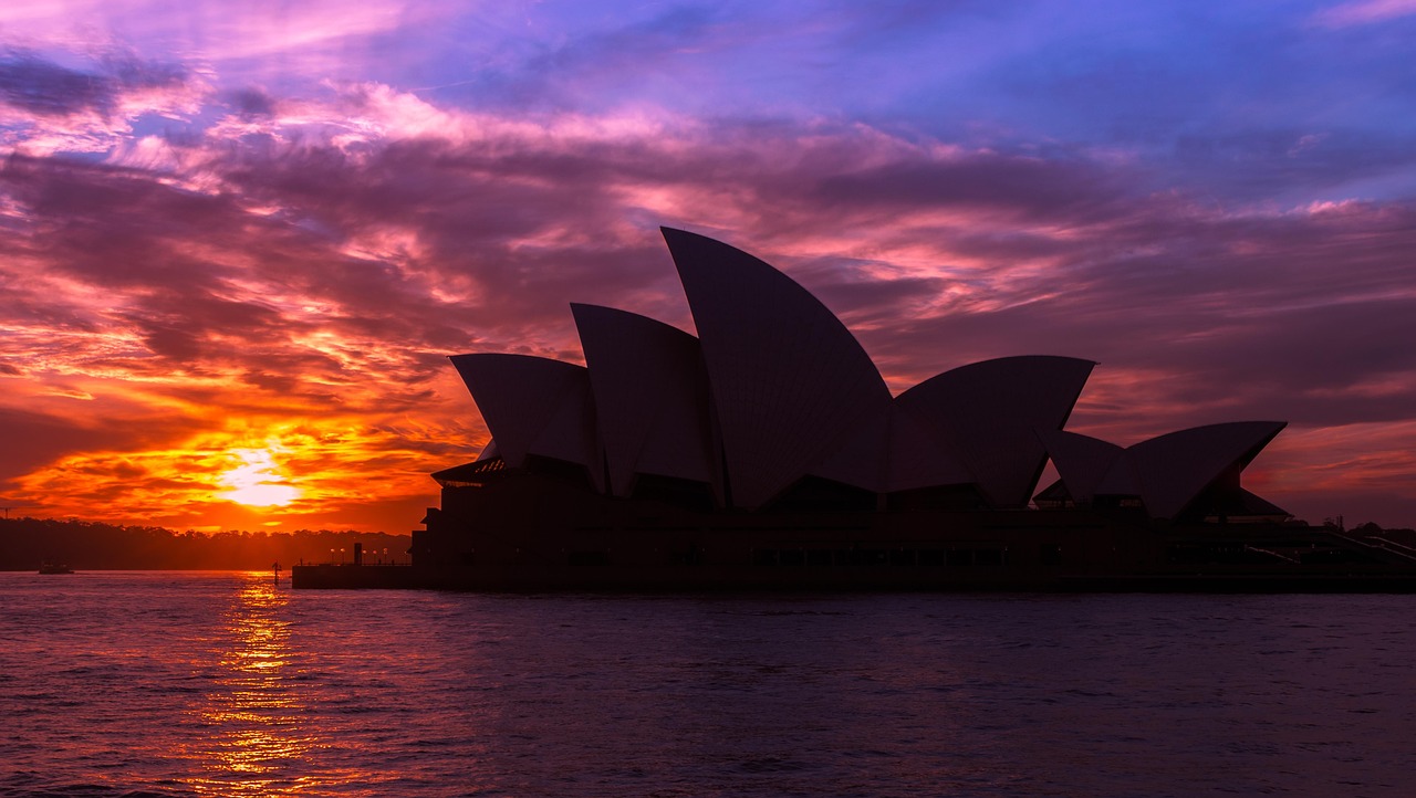 Sydney Opera House at golden hour with harbour bridge and water reflections