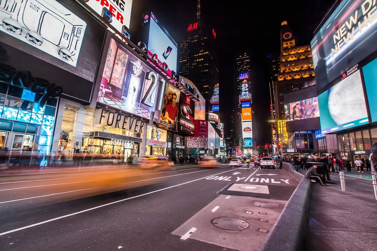 A bustling, rain-glistened Times Square at night — a high-energy, saturated scene that epitomizes why NYC is a top global travel destination for landmark photography Times Square at night with vibrant LED billboards, crowds, and yellow cabs moving through wet pavement