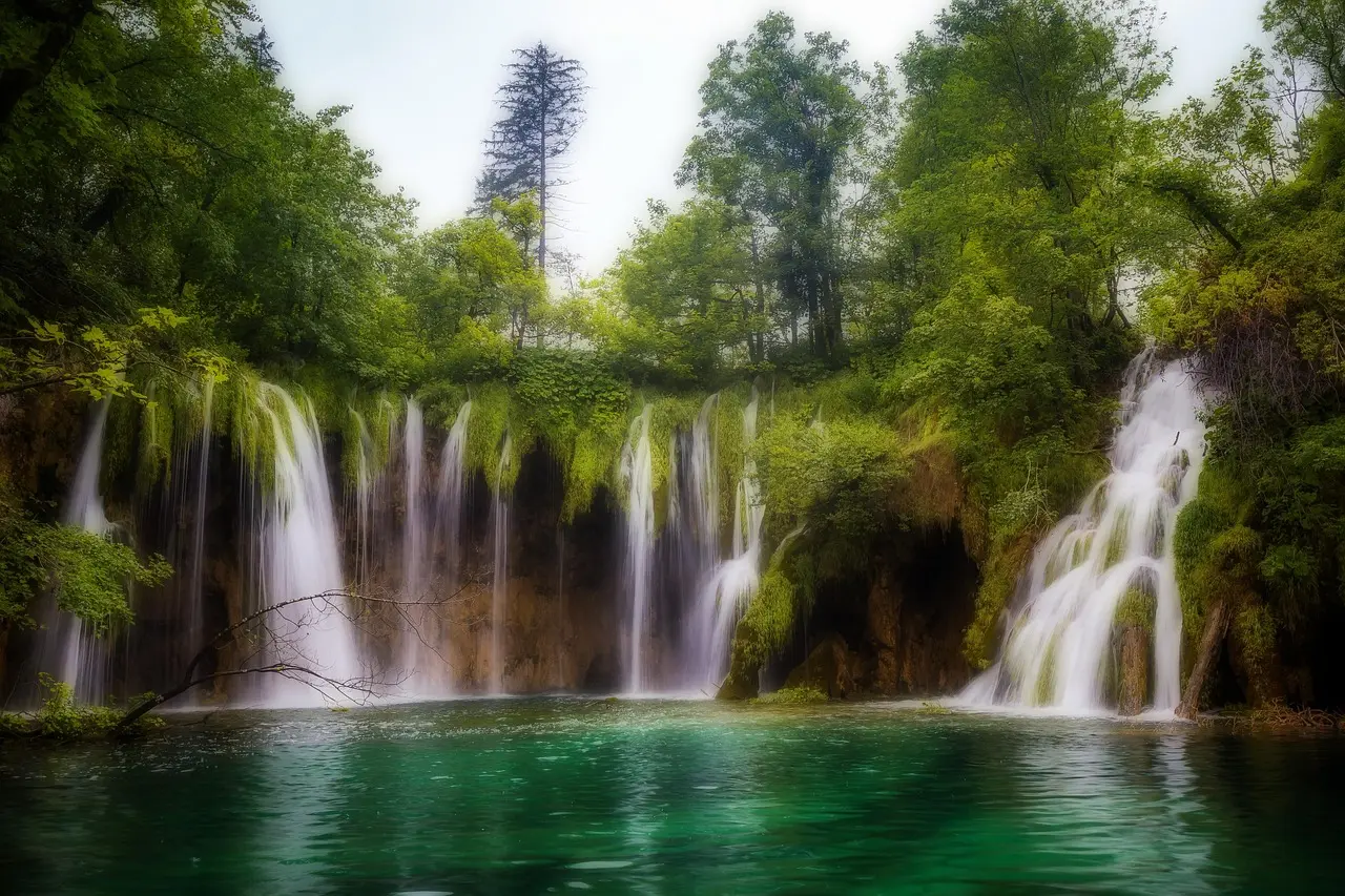 Harmonious integration of infrastructure and wilderness — how Plitvice enables mindful appreciation of natural scenery Aerial view of Plitvice Lakes’ cascading turquoise waters and wooden boardwalks winding through forest