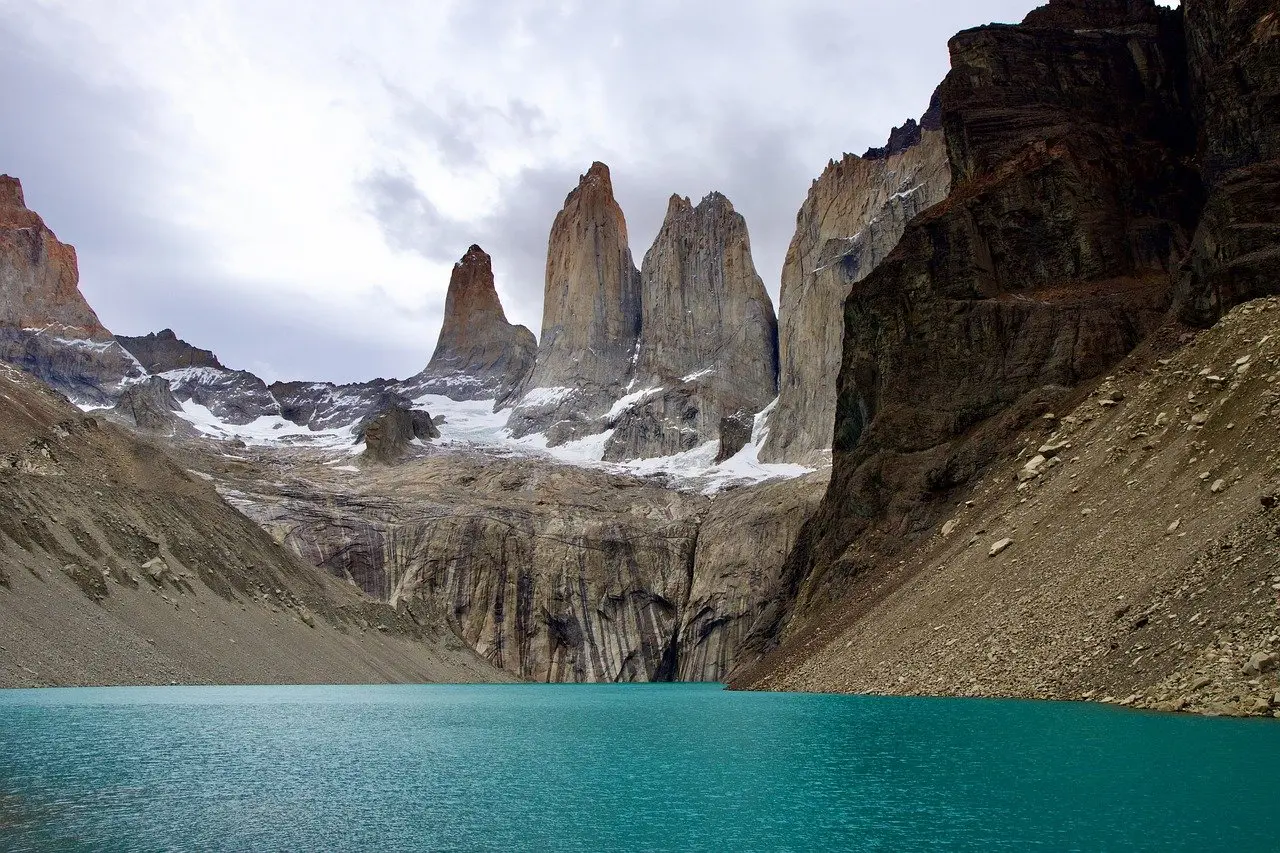 Sunrise over the Paine Massif — a quintessential Patagonian moment to appreciate natural scenery Dramatic sunrise illuminating the three granite Torres del Paine peaks reflected in still glacial lake water