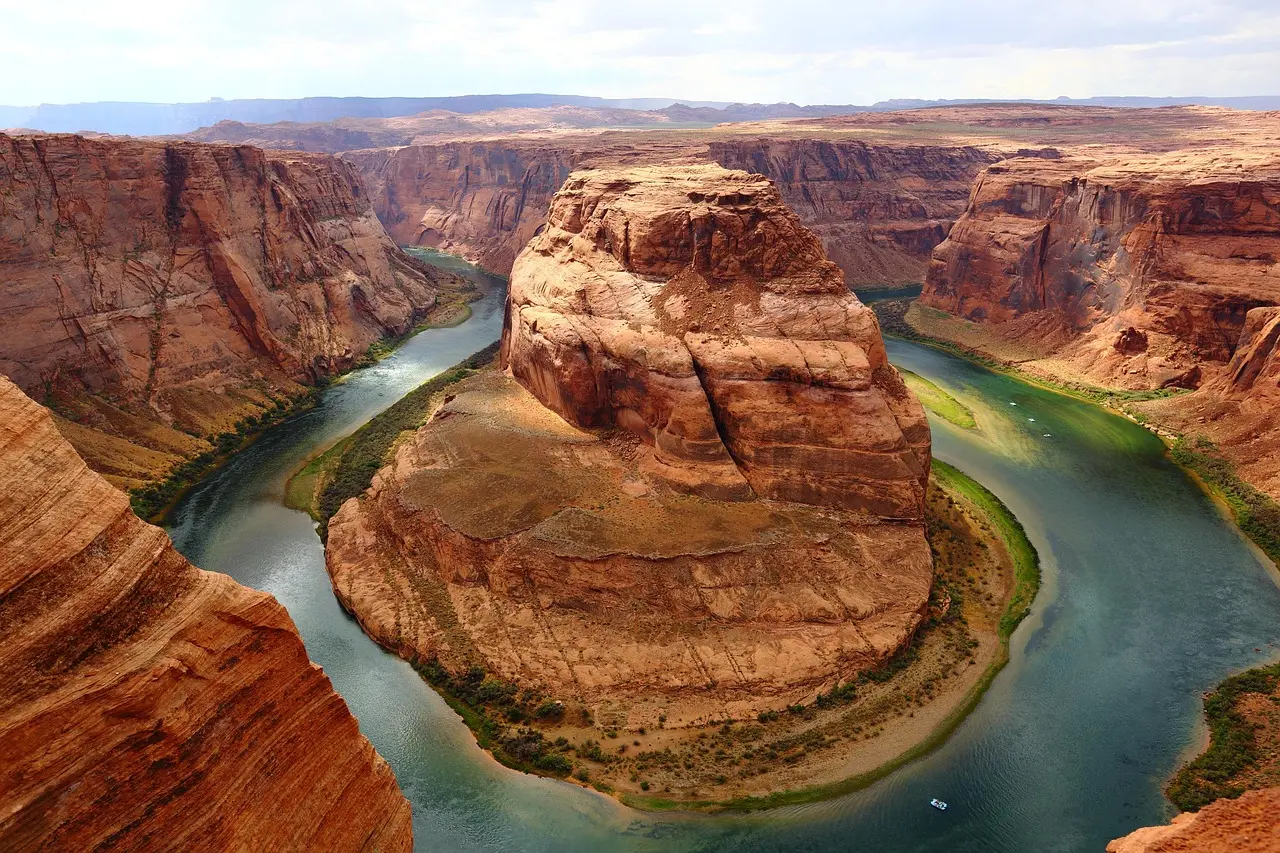 An aerial perspective revealing how geology shapes the experience of appreciating natural scenery in Arizona Aerial drone shot of the Grand Canyon’s winding Colorado River surrounded by layered red and orange rock cliffs